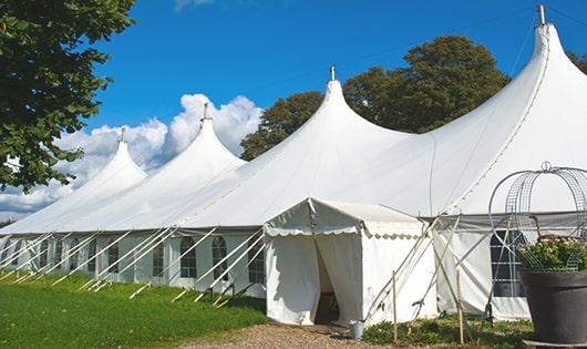 a row of green and white portable restrooms at an outdoor event venue in Lynnfield, MA